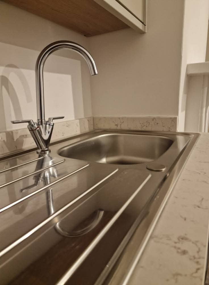 Gleaming stainless steel kitchen sink and tap